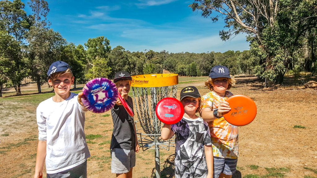 An iamge of group of kids holding frisbee