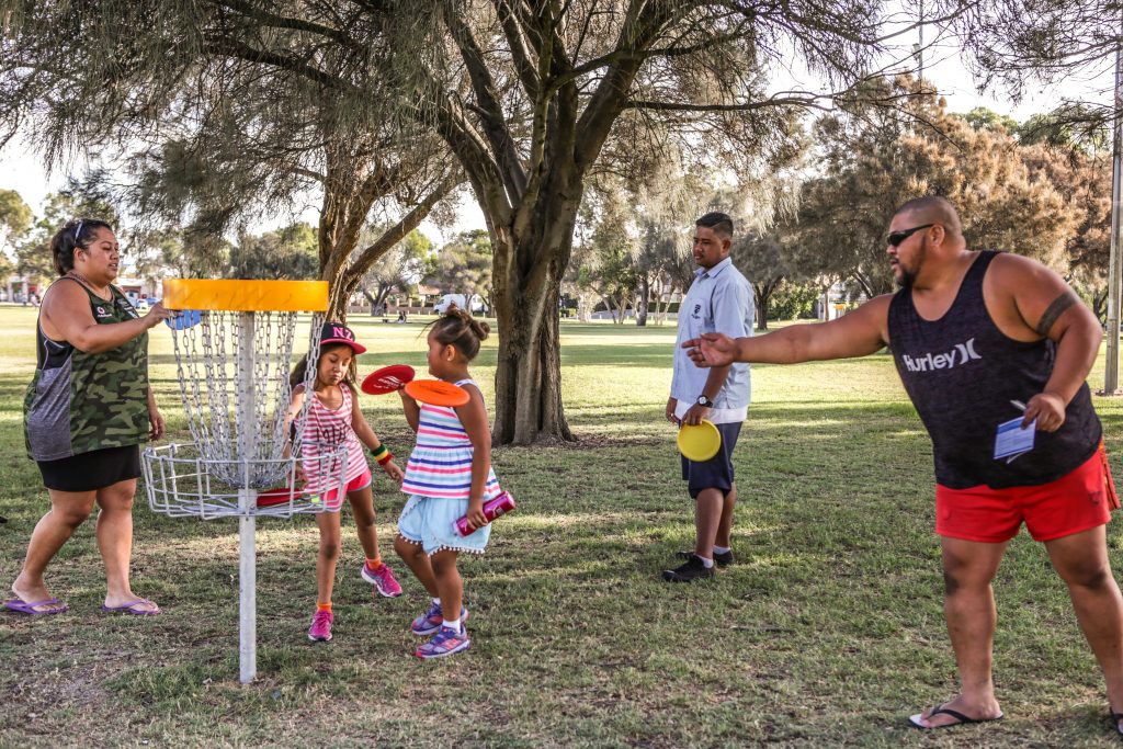 An image of family playing disc golf in a disc golf park