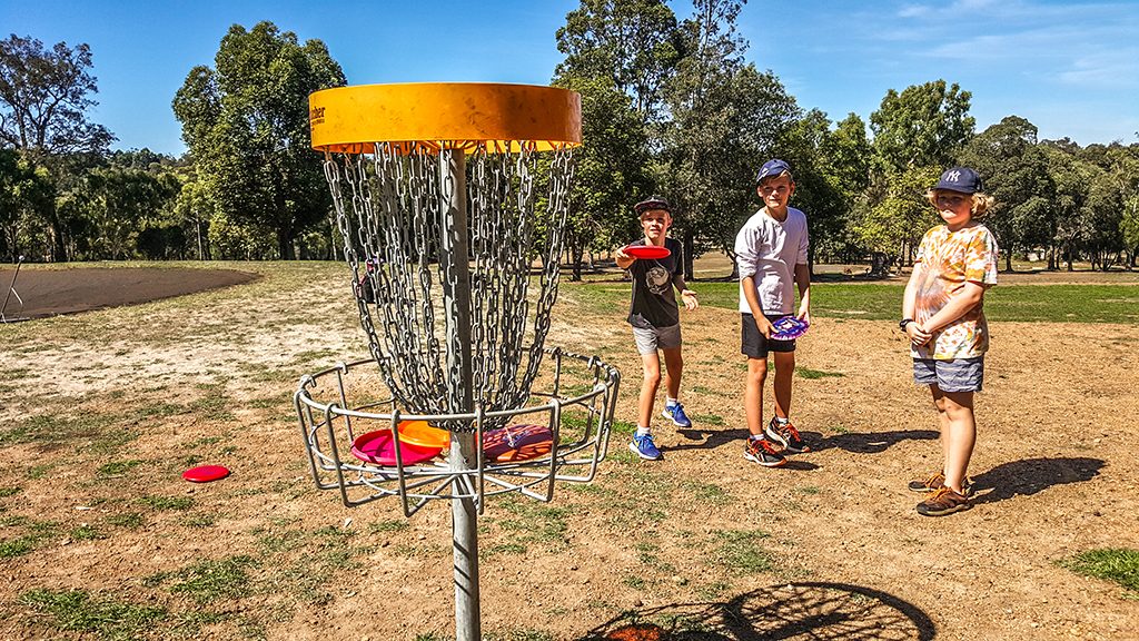 an image of kids playing disc golf