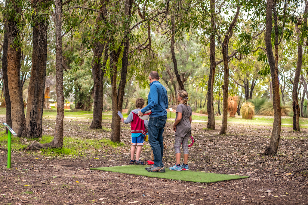 An image of family playing disc golf