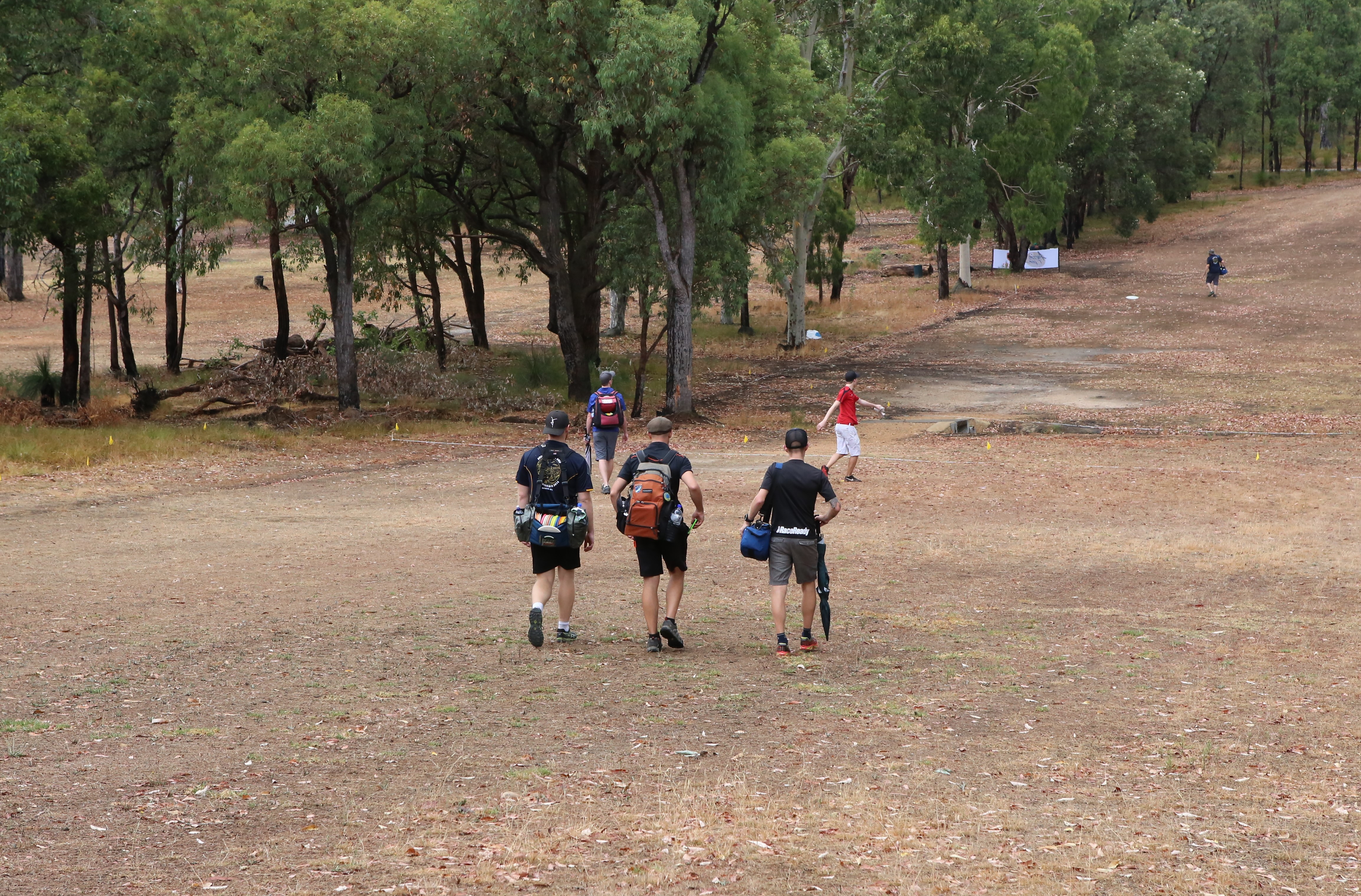 an image of group of people walking in a disc golf course