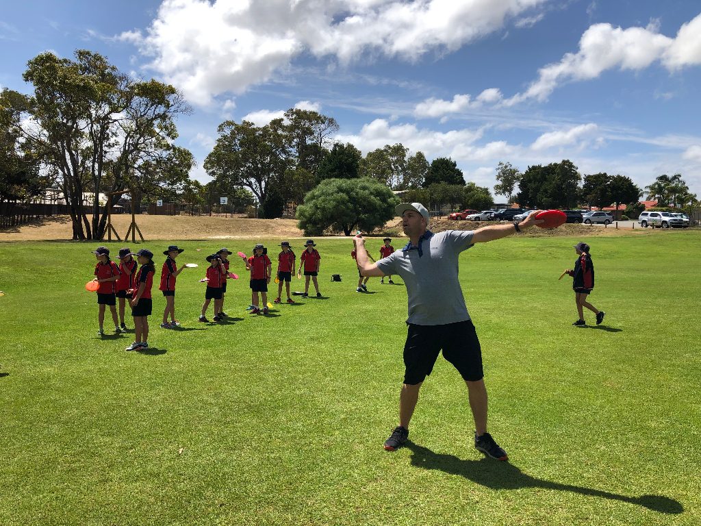 an image of group of kids under training of disc golf