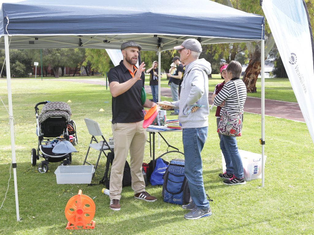 an iamge of two men talking in a disc golf park